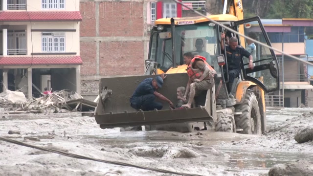 En kvinne ble reddet ut av flommassene. Video: Reuters