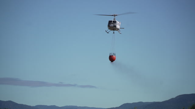 Det første helikopteret som kom til Krokstadelva viser korleis dei slokkar brannar frå lufta.Willliam Jobling / NRK