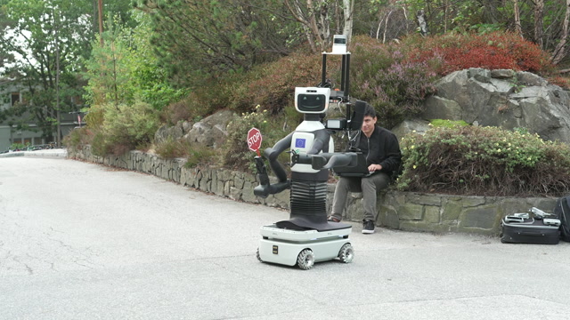 Roboten slipper en bil forbi. Roboten får også hjelp av en drone til å analysere trafikkbilde. Havard Axel Kator